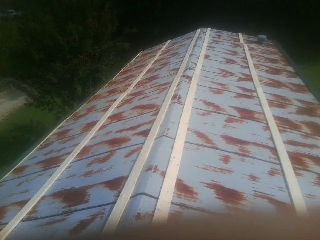 Rusted metal roof panels with new wood purlins before replacement — Storm Damage Roof Repair in Blakeslee by Roofing Brothers