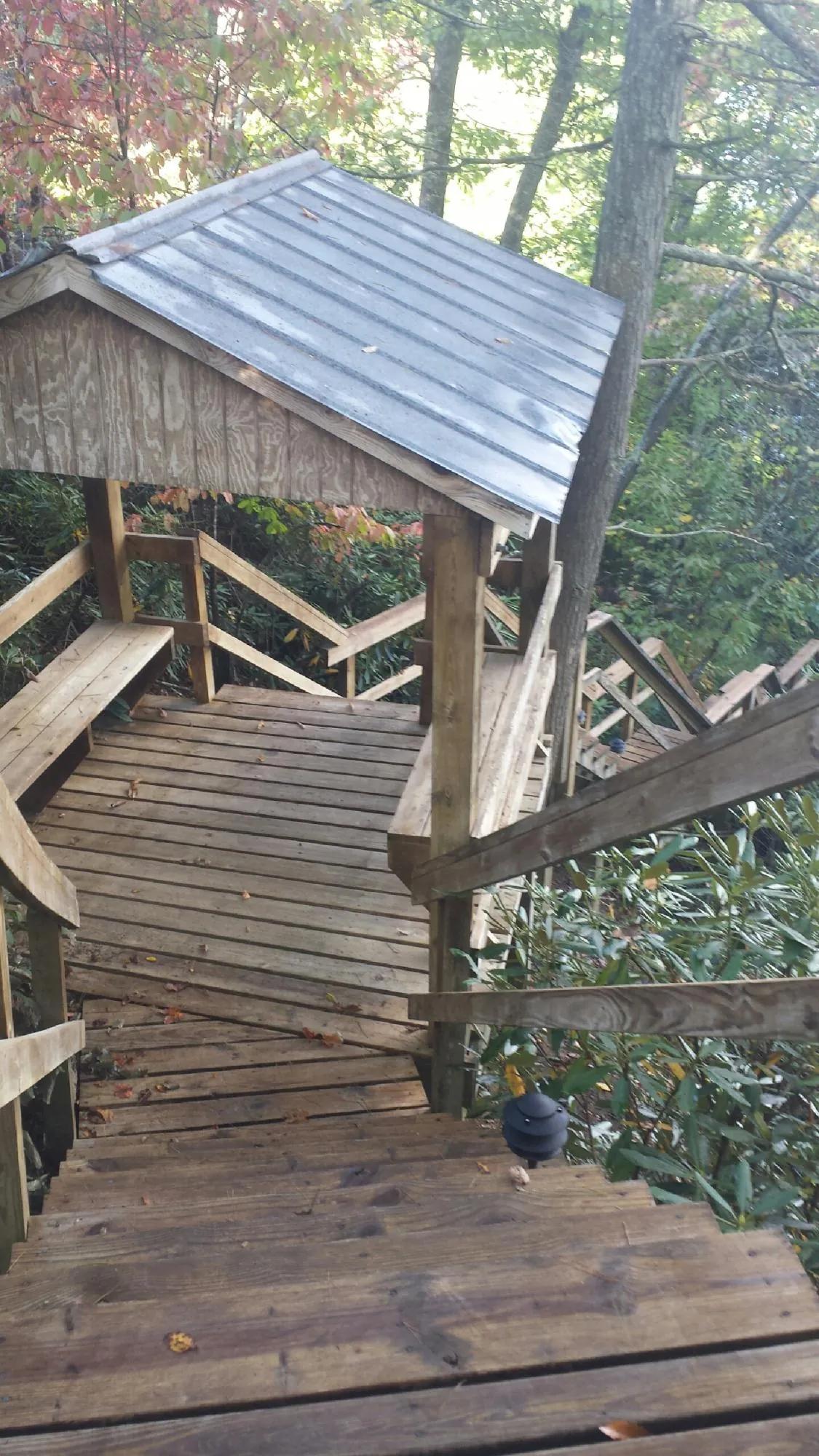 Metal roofed shelter over wooden steps on a wooded walkway — Skylight Repair & Installation work by our crew in Blakeslee