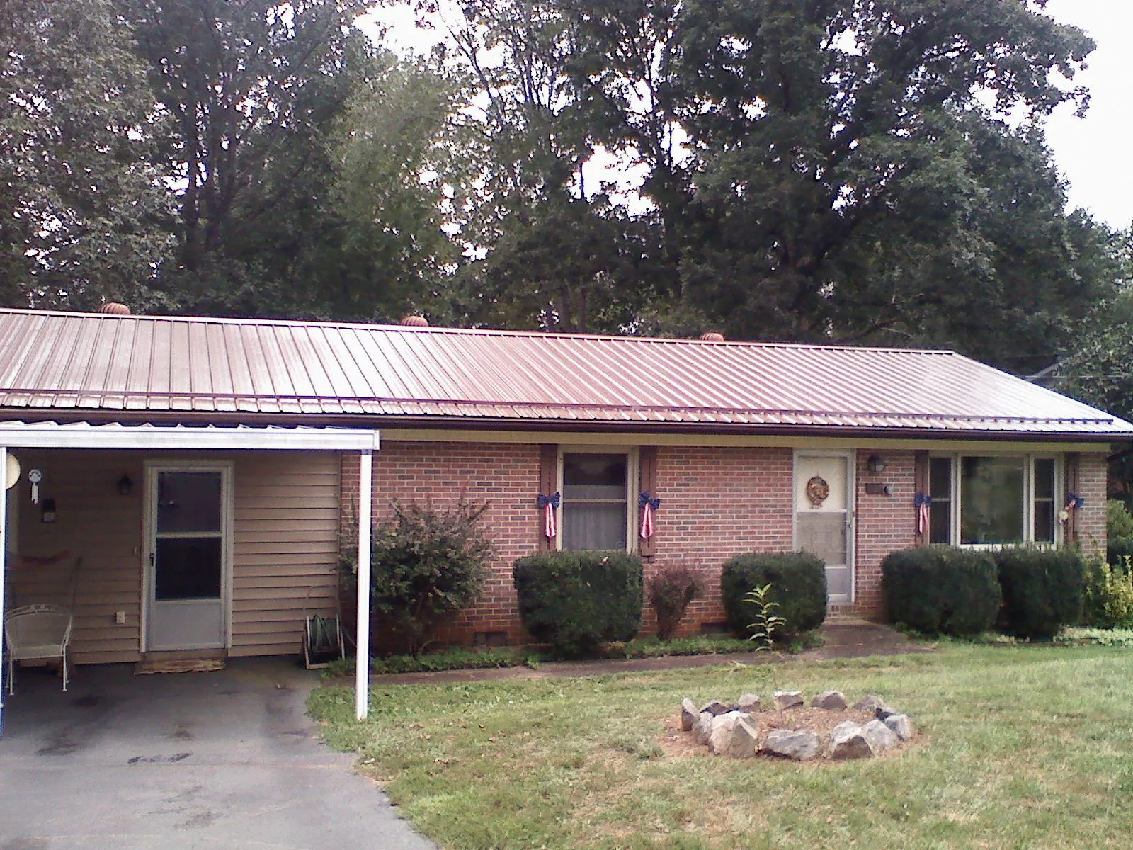 Bronze metal roof and carport on a brick ranch home — Roof Repair work by our crew in Blakeslee